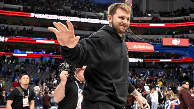 Luka Doncic saluda al público en las gradas vistiendo pants negros